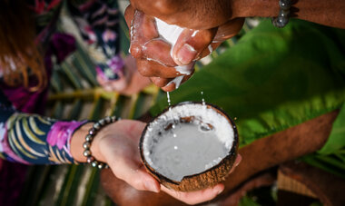 Photo d'une personne qui essore un tissu pour en faire couler le lait de coco